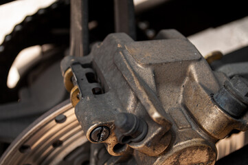 a golden yellow motorbike caliper that looks dirty and dusty
