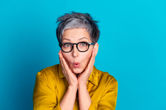Photo of adorable shockes lady dressed shirt eyewear arms cheeks empty space isolated blue color background