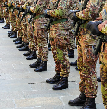 Black combat boots of army soldiers in camouflage uniforms standing in formation