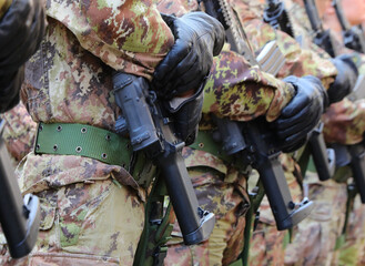 platoon of many army soldiers in camouflage uniform and assault rifle during parade