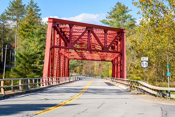 Deserted red steel bridge on a highway in the mountains on a clear autumn day