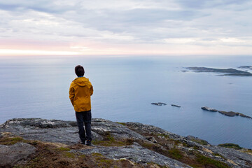 Family with children and pet, hiking Sukkertoppen trail on Senja island, Norway