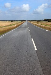 long straight stretch of asphalt road without people on the plain and without cars