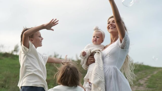 The family catches soap bubbles and rejoices. - Powered by Adobe