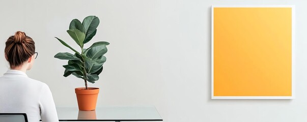 Bright office with a minimalist glass desk, a single potted plant, and abstract wall art, emphasizing openness and creativity