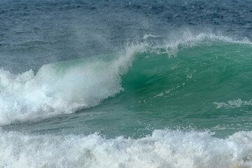 Wave of the green and blue Atlantic Ocean at the edge of a beach in the Iroise Sea.