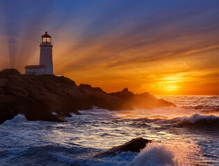 Fototapeta premium A lighthouse burning on the shore of the swirling sunset sea