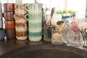 A table with many cups and glasses, some of which are floral