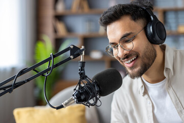 Hispanic man enjoying podcast recording with headphones and microphone in a comfortable home setting