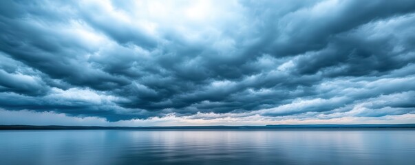 Fototapeta premium Storm clouds moving in over a calm lake, approaching weather, impending storm