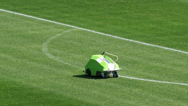 Automated line marking machine painting white lines on soccer field