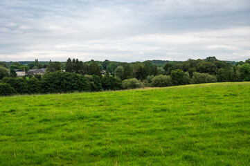 Obraz premium Green hills and meadows at the Belgian countryside with the Chateau Thor in the background, Lontzen, Belgium