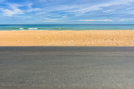 Side view of asphalt road with beach on sea and beautiful blue sky.