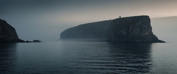 View of a dark foggy cliff with quiet sea.