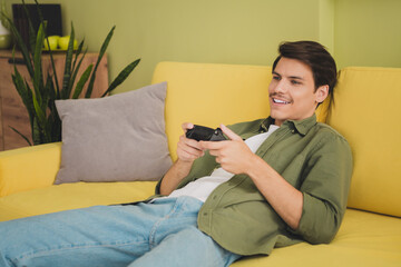 Obraz premium Photo of cheerful funny man wearing stylish clothes sitting cozy divan spending free time modern interior house indoors