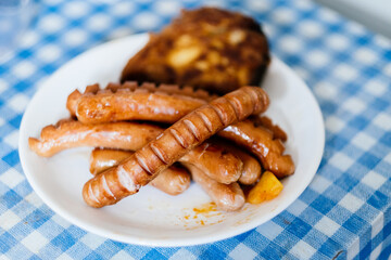 sausages on a plate in a traditional tablecloth
