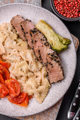Bowl with slices of baked tuna with broccoli, tomatoes and fusili pasta