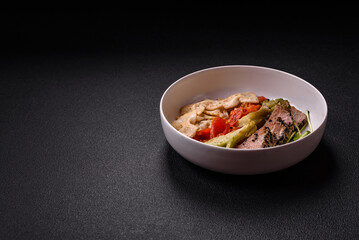Bowl with slices of baked tuna with broccoli, tomatoes and fusili pasta