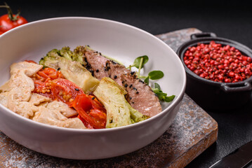 Bowl with slices of baked tuna with broccoli, tomatoes and fusili pasta