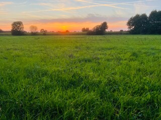 Fantastic sunset sky in the green field, twilights in the countryside