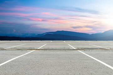 Empty parking lot against beautiful landscape on sunset sky.