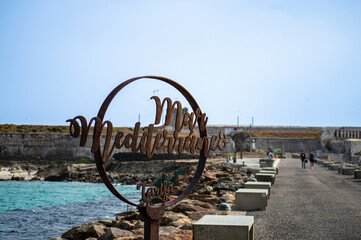 Fototapeta premium The famous symbol on the pathway that divides the Atlantic Ocean from the Mediterranean Sea in Tarifa, Spain