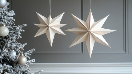three paper stars dangle from the ceiling as part of a chic christmas decor, blending minimalism with a touch of holiday spirit in a trendy interior design