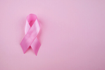 Pink ribbon on color background, top view. Breast cancer awareness concept