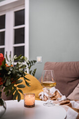 A Cozy Living Room Featuring Wine and Softly Flickering Candles for a Perfect Ambiance