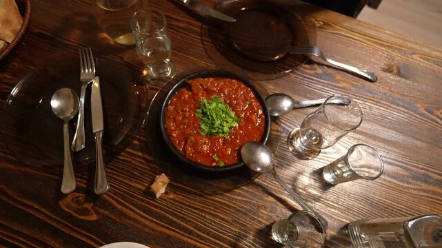 On table there are cutlery and delicious chanakhi mlm ostri traditional Georgian stew with meat and vegetables