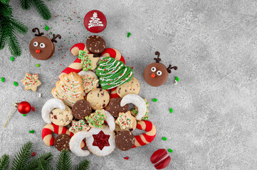 Christmas tree made from different homemade cookies on a gray concrete background. Holiday food. Top view, copy space.