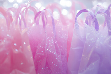 Fototapeta premium A background filled with sparkling gift bags and shimmering tissue paper, in soft pink and lavender tones.