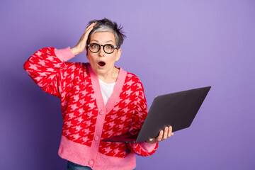 Photo portrait of pretty retired female hold netbook frightened amazed wear trendy red outfit...