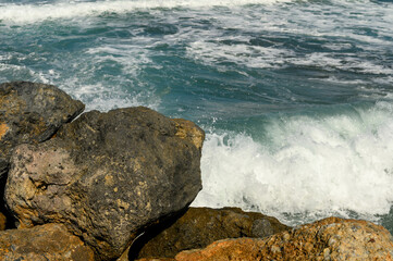close-up of waves in the Mediterranean Sea crashing on rocks near the shore