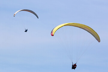 Paragliders flying in a blue sky	
