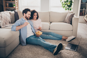 Full size photo of two nice young partners watch movie eat chips weekend modern apartment indoors