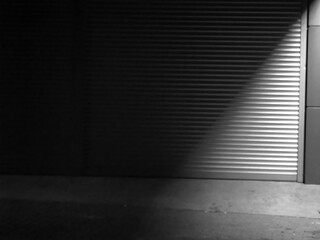 Illuminated Street Corner by Garage Door—Parking Spot at Night in Black and White.