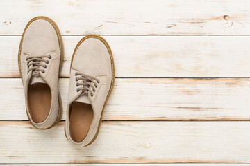 Beige suede shoes on wooden background, top view