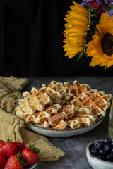 Belgian waffles with blueberries and strawberries  on plates on the table