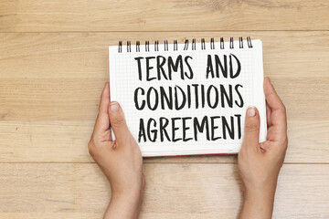 hands holding a notebook with terms and conditions agreement concept
