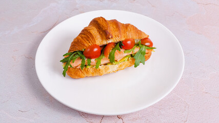 Salmon croissant sandwich on plate