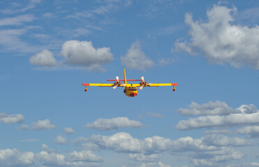 Seaplane in full flight in the sky with clouds, fighting fires