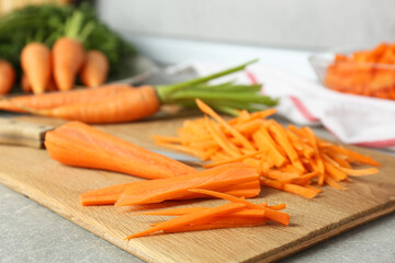 Pieces of fresh carrots on gray textured table, closeup