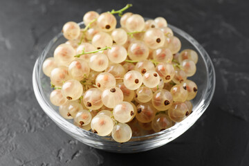 Fresh white currant berries in bowl on gray textured table, closeup
