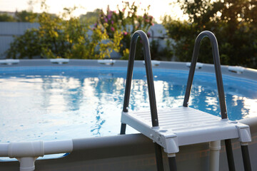 Above ground swimming pool with ladder outdoors