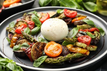 Tasty salad with grilled vegetables and mozzarella cheese on black table, closeup