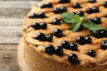 Delicious homemade blueberry pie with mint on table, closeup
