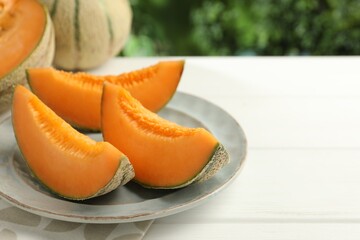 Pieces of fresh Cantaloupe melon on white wooden table, closeup. Space for text