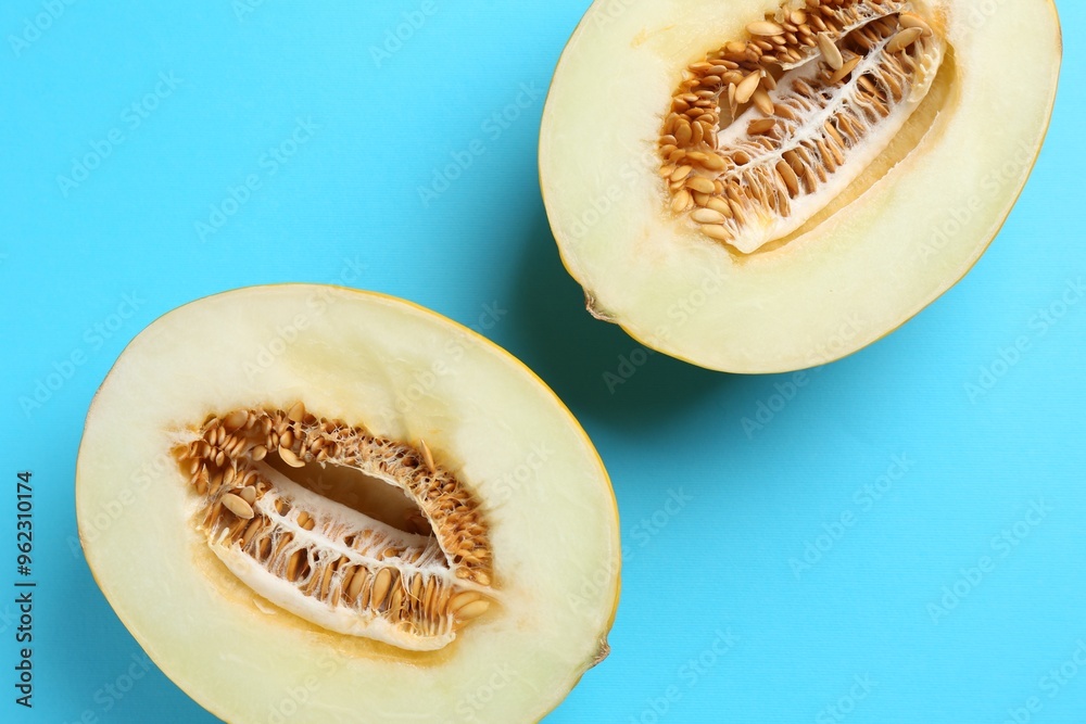 Sticker Halves of fresh melon on light blue background, top view