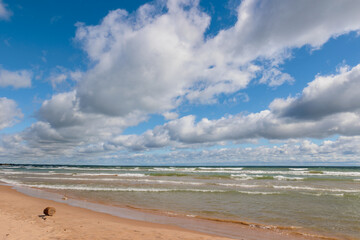 Obraz premium The clouds form converging lines pointing north along the shoreline of Lake Michiganat Harrington Beach State Park, Belgium, Wisconsin in early September
